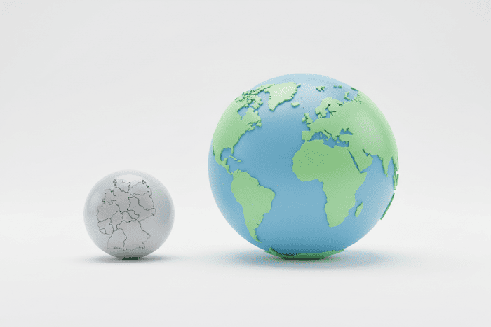 Größenvergleich der Marktkapitalisierung: Eine kleine Kugel mit Deutschland-Karte (DAX) neben einer riesigen Weltkugel (MSCI World).