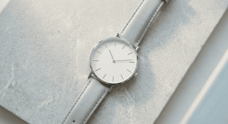 Eine elegante, minimalistische Armbanduhr auf einem hellen Hintergrund, die den Zeitwertvorteil bei Stillhaltergeschäften verdeutlicht.